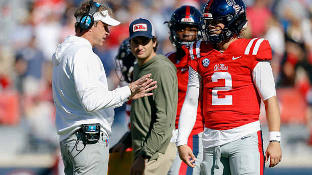 Nov 18, 2023; Oxford, Mississippi, USA; Mississippi Rebels head coach Lane Kiffin (left) talks with Mississippi Rebels quarterback Jaxson Dart (2) during a time out during the first half against the Louisiana Monroe Warhawks at Vaught-Hemingway Stadium. Mandatory Credit: Petre Thomas-USA TODAY Sports  